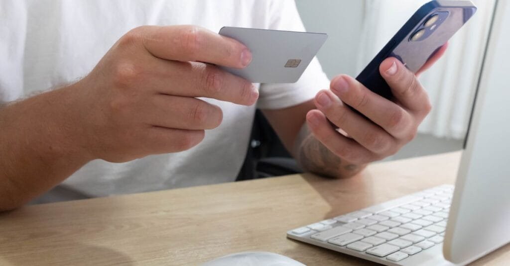 Person shopping online with card and phone