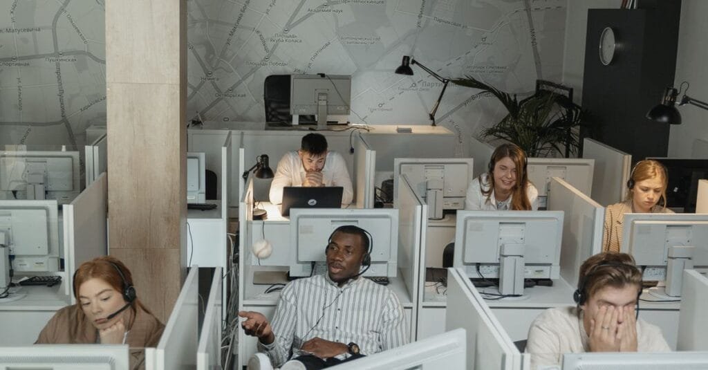 Support team working at computers with headsets