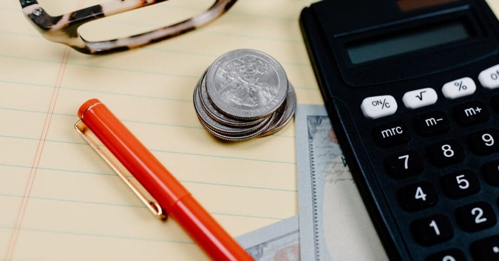 Calculator, coins and cash on a desk