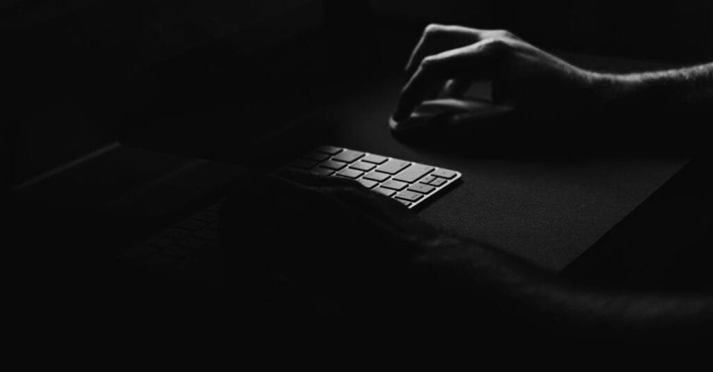 Hand typing on a keyboard in low light