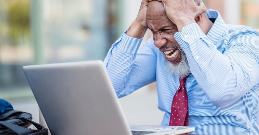 Man frustrated at a laptop