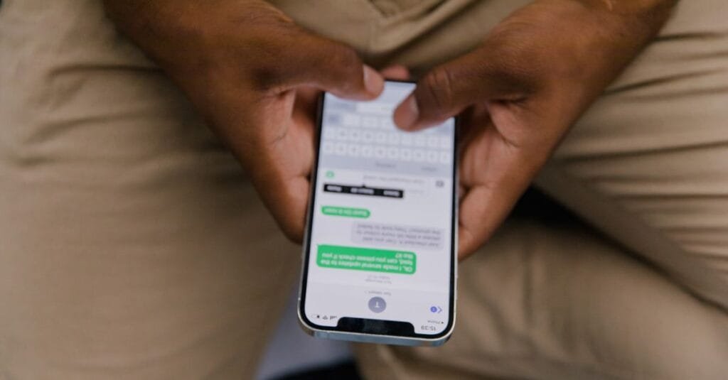 Hands typing a message on a smartphone